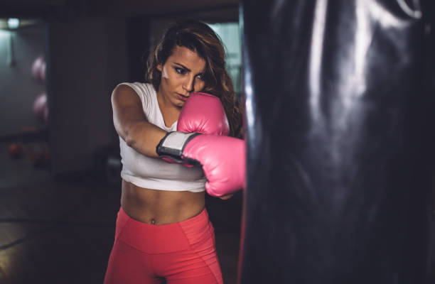 istock Beautiful lady boxer training alone in gym 1130689002