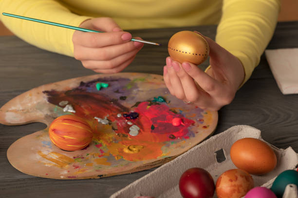 istock Women gently paints colorful easter egg 1130689023