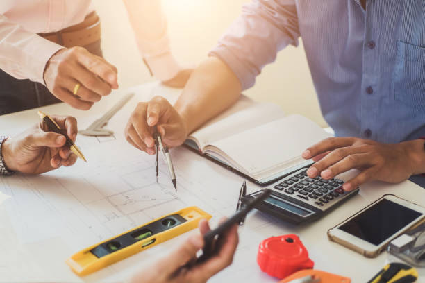 istock Team of professional architects working building plan design project with blueprints and engineering tools at design office. Construction and structure concept. 1130690265