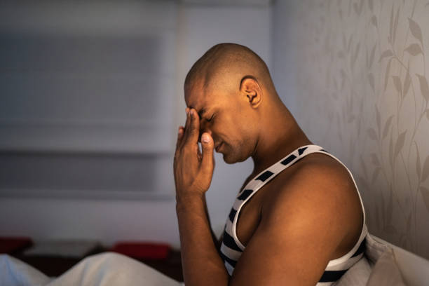 istock Afro man with headache at home 1130690415