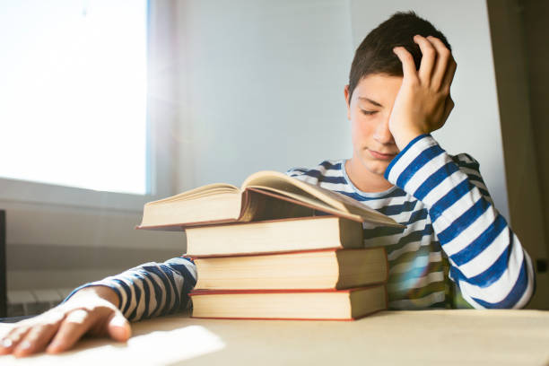 istock Bored boy sleeping on the books 1130690462