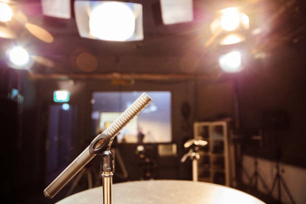 istock Speaker on the stage: Young Caucasian man is talking into a mirophone 1130692385