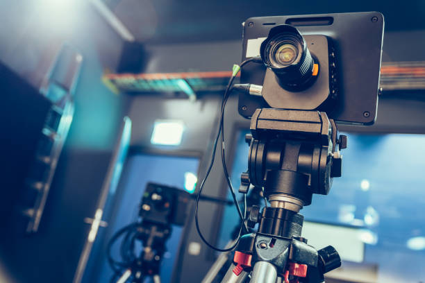 istock Modern film camera on a tripod in a broadcasting studio, spotlights and other equipment 1130692474