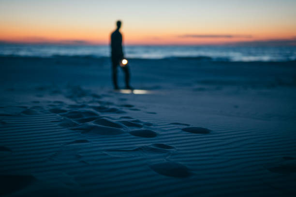 istock Lonely man on beach in Autumn 1130693639