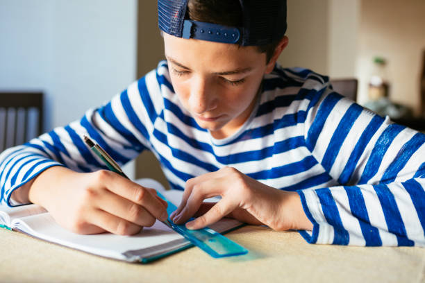 boring homework pictures Teenage boy doing homework at living room Photo of teenage boy doing homework at home boring homework twelve stock pictures, royalty-free photos & images