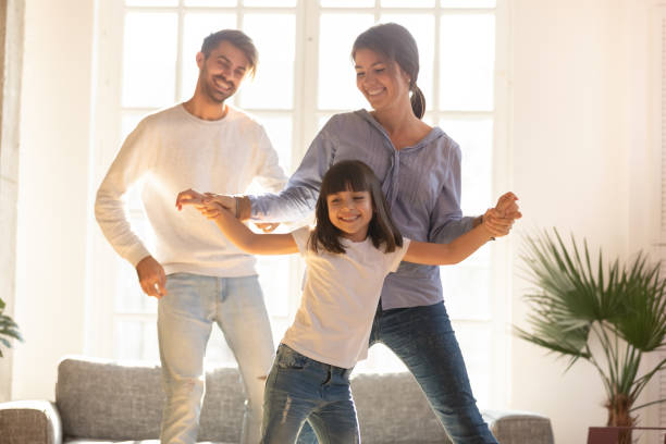 feliz familia y niño hija riendo bailando en la sala de estar - common family new togetherness fotografías e imágenes de stock