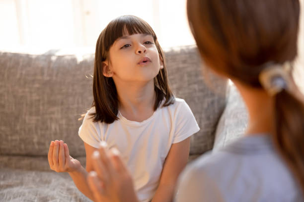 ragazza bambina balbuzinte carina che parla facendo esercizi con il logopedista - singing lesson foto e immagini stock