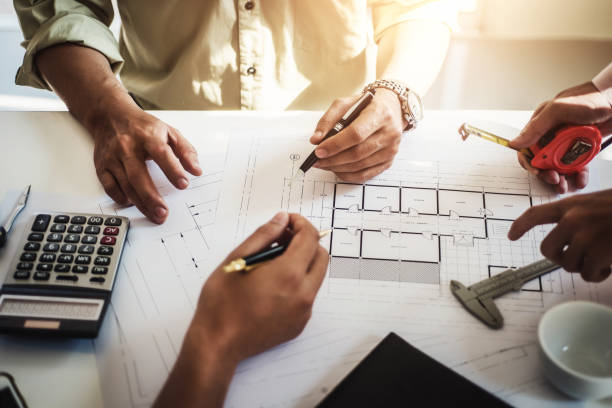 engineer people meeting working and pointing at a drawings in office for discussing. Engineering tools and construction concept. engineer people meeting working and pointing at a drawings in office for discussing. Engineering tools and construction concept. building floor plan stock pictures, royalty-free photos & images