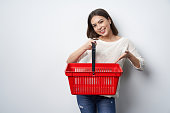 Woman holding showing empty shopping basket pointing