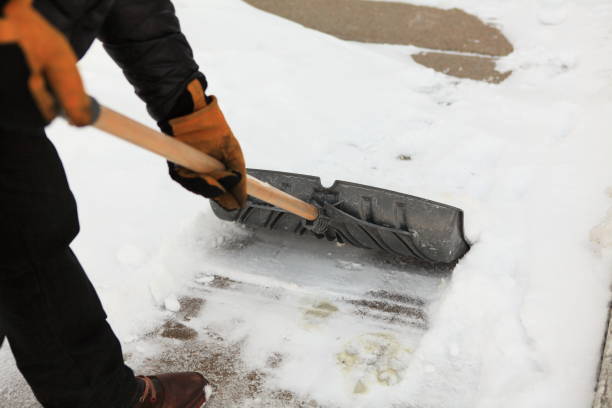 Man clean a sidewalk by shovel