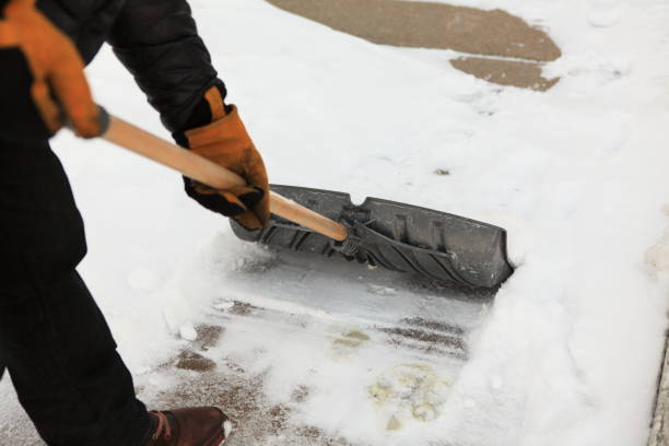 Man clean a sidewalk by shovel stock photo