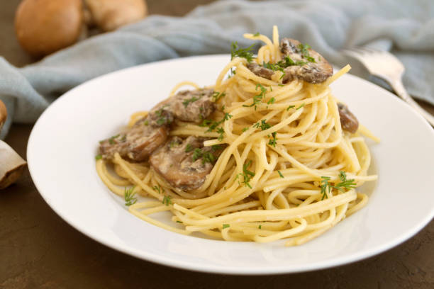 istock Spaghetti with mushrooms in cream sauce. on dark background 1130701283