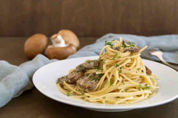 istock Spaghetti with mushrooms in cream sauce. on dark background 1130701294
