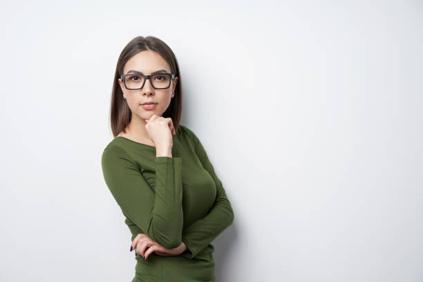 Confident woman in glasses standing looking at camera