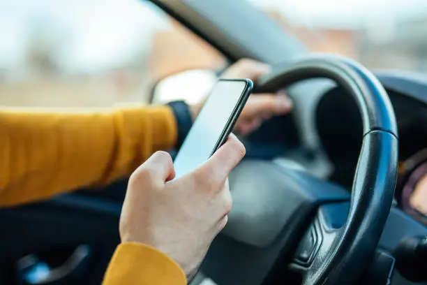 Shot of a male using mobile phone while driving the car.