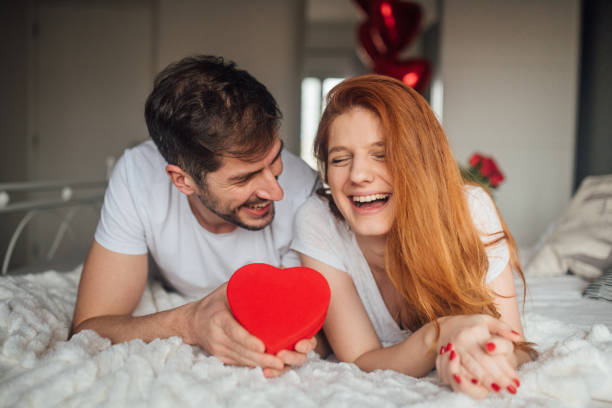 istock Young couple smiling when holding a gift 1130703885