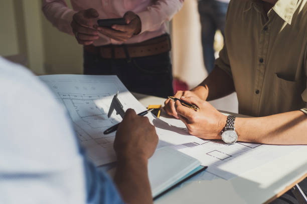 istock engineer people meeting working and pointing at a drawings in office for discussing. Engineering tools and construction concept. 1130707718