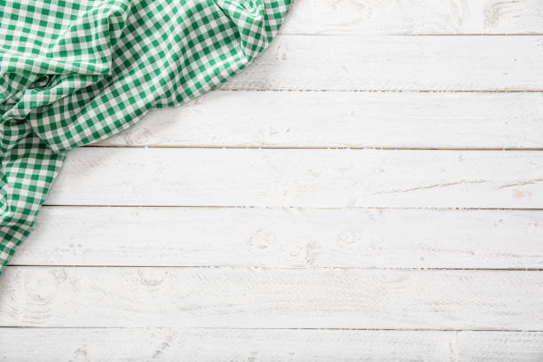 istock Green checkered kitchen tablecloth on wooden table. 1130707828
