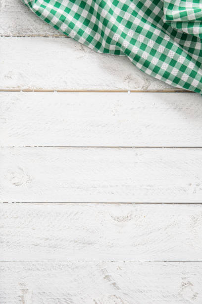 istock Green checkered kitchen tablecloth on wooden table. 1130707833
