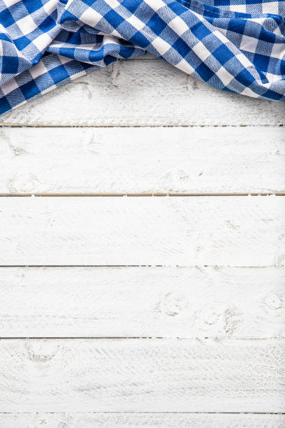 istock Blue checkered kitchen tablecloth on wooden table. 1130707860