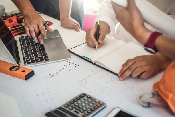 istock Asian architect business people group discussion on meeting with construction blueprints plan. Construction engineering tools and structure concept. 1130707869