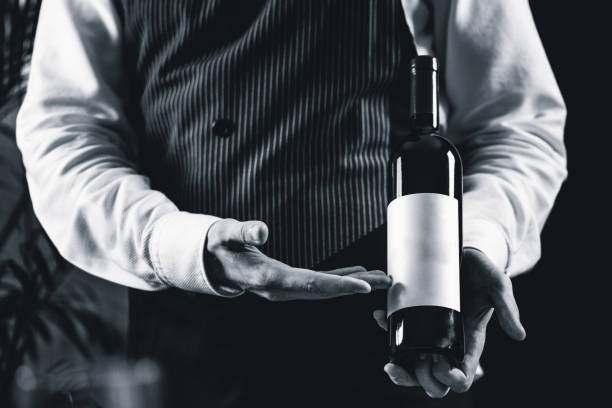 istock Midsection Of Bartendar Holding Wine Bottle In Bar 1130708132