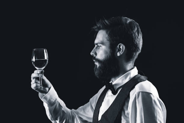 istock Bartendar Looking At Wineglass In Bar 1130708145