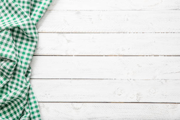 Green checkered kitchen tablecloth on wooden table.