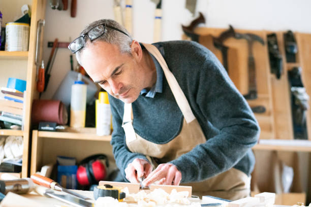 istock Carpenter using a chisel to refine rebate in wooden furniture component 1130710061