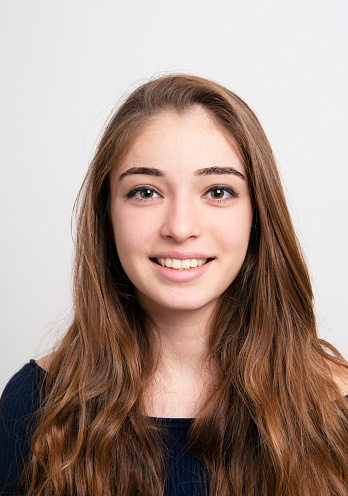 Photo of teen girl smiling portrait against yellow background in studio close up