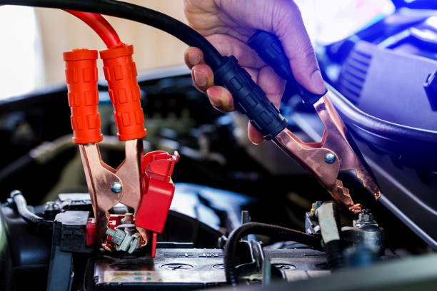 istock selective focus charging car with electricity trough cables. 1130711627