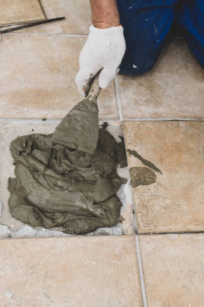 istock Tiling Floor outdoor. The tiler builder professional arranges the veranda tile, selective focus 1130712050
