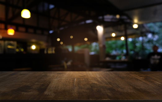 Mesa de madera oscuro vacío delante de fondo abstracto borrosa bokeh del restaurante. puede ser utilizado para la exhibición o montaje de sus productos. Simulacro para el espacio. photo