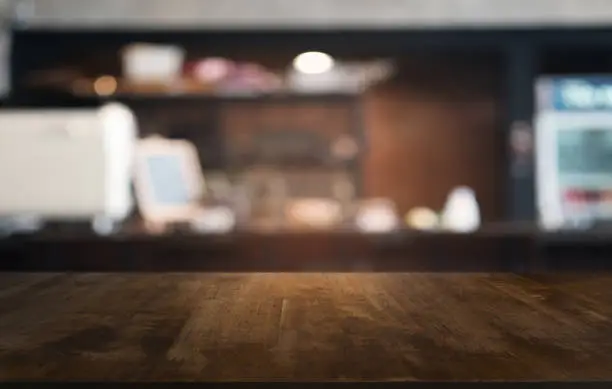 Empty dark wooden table in front of abstract blurred bokeh background of restaurant . can be used for display or montage your products.Mock up for space