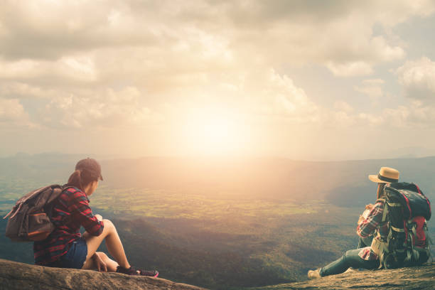 istock Women Sitting On Rock Against Sky During Sunset 1130715642