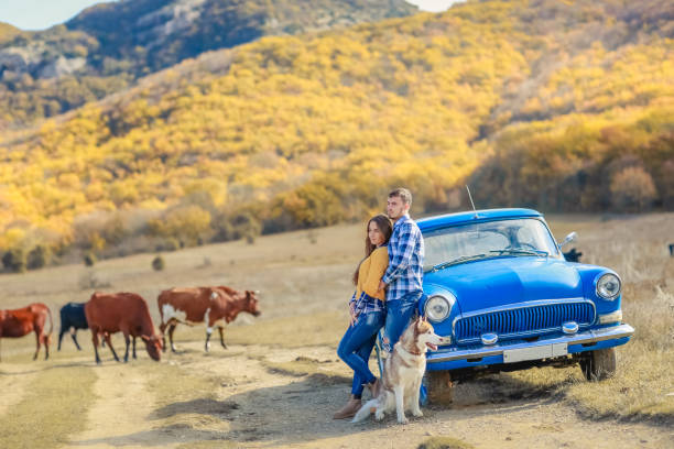 istock Couple with dog having fun with hay stack on wheat field on warm summer evening. 1130721087