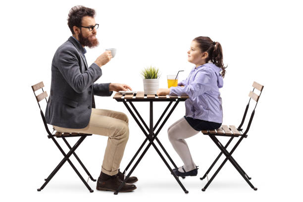 istock Father and daughter at a cafeteria drinking coffee and orange juice 1130721439