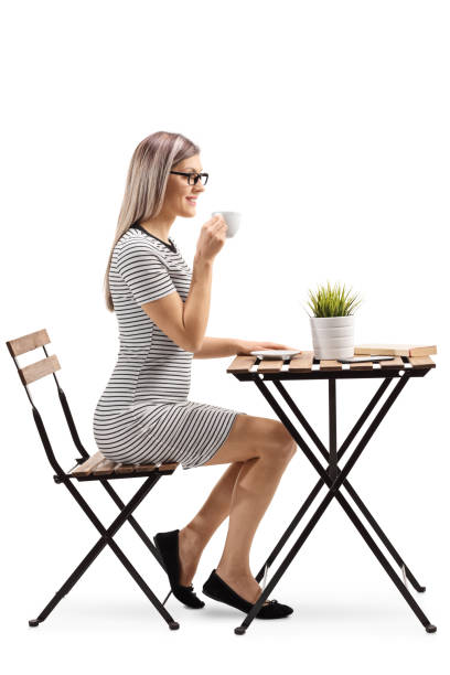 istock Young woman drinking coffee and sitting at a table 1130721631