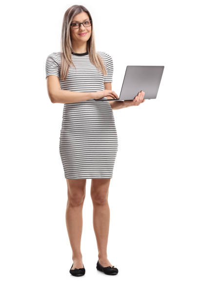 istock Young woman standing and holding an open laptop computer 1130722623