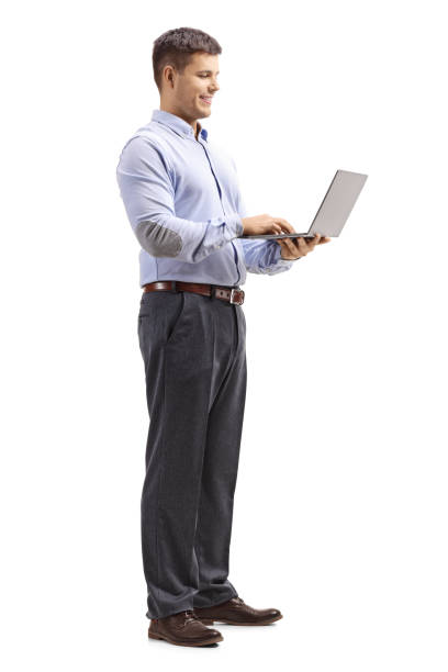 istock Young man in formal clotes holding a laptop computer and looking at it 1130723206