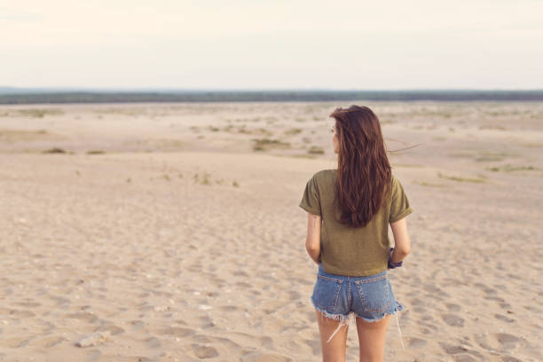istock Rear view young woman lost in desert 1130724083