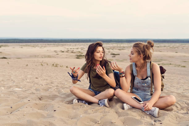 Lost friends talking while sitting in desert