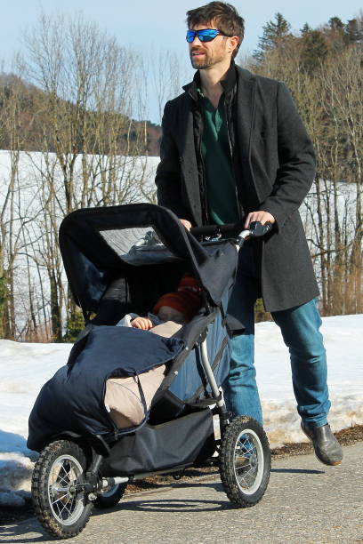 istock Father with stroller in the snow 1130726393