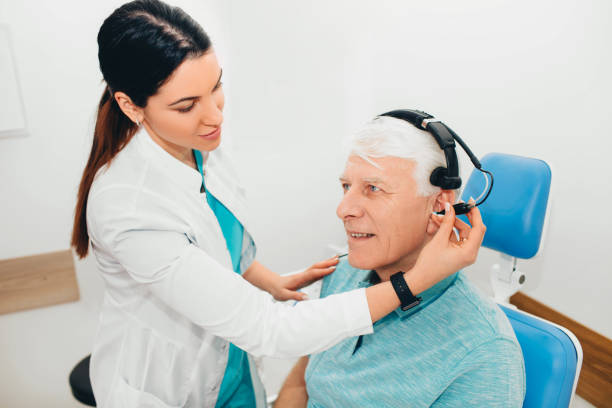 Senior man having hearing test with special medical equipment Senior man in hospital having ear test. assistive technology photos stock pictures, royalty-free photos & images