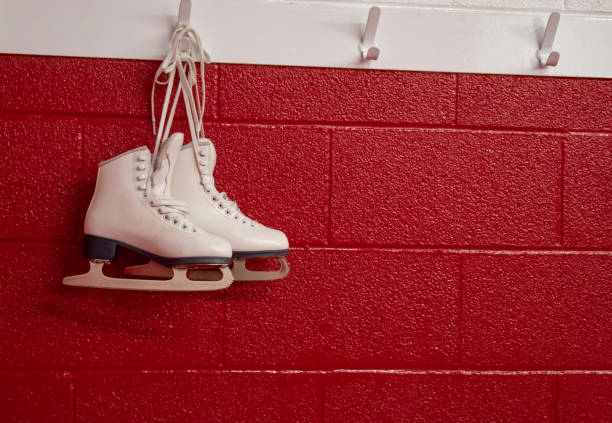 istock Figure skates hanging over red wall in locker room with copy 1130732902