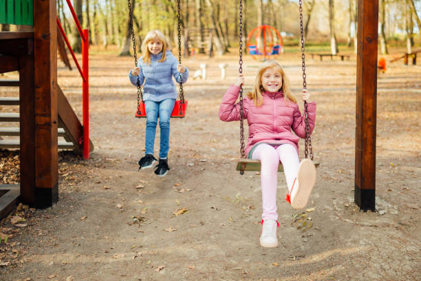 istock Twin sisters playing in the park 1130733937