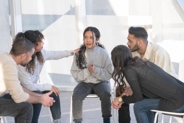 istock Young adults consoling a friend in group therapy 1130735321