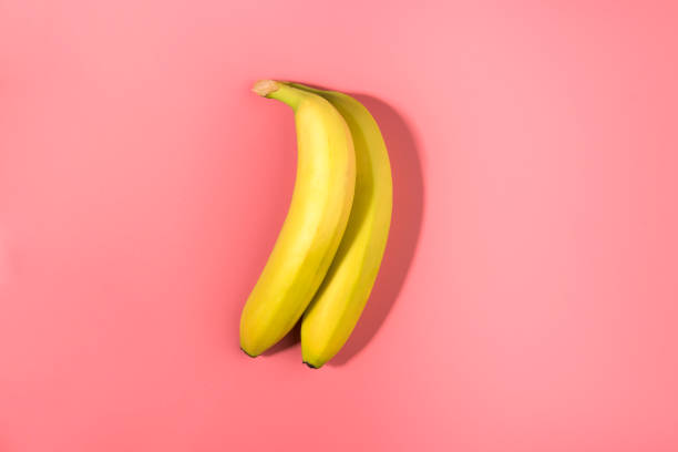 istock Two bananas on a pink background with contrast shadow 1130736761