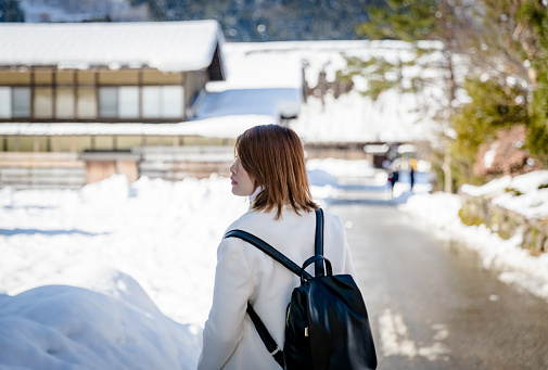 Beautiful Asian woman tourist with white snow winter at Shirakawa-go village, Japan