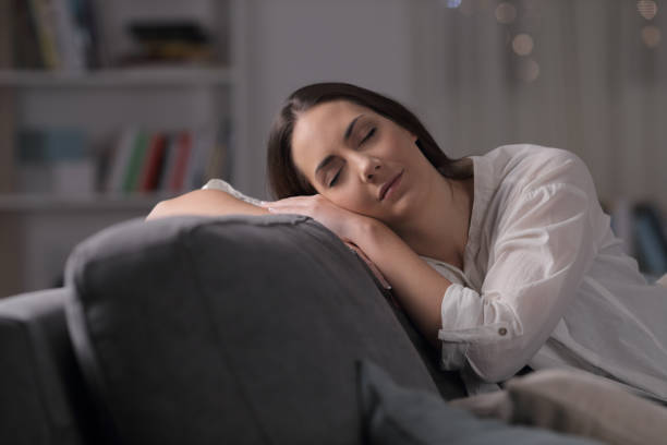 istock Woman sleeping on a couch in the night at home 1130737988